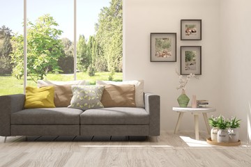 Stylish room in white color with sofa and summer landscape in window. Scandinavian interior design. 3D illustration