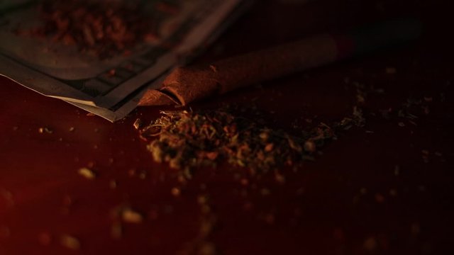 marijuana on the table, preparing to twist the jamb