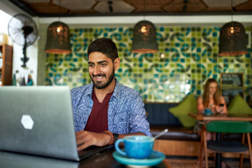 Handsome millennial indian man working in trendy coworking space - 305785494