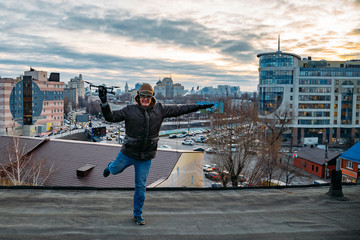 Fototapeta na wymiar Young happy hipster man with drone in hands on the roof