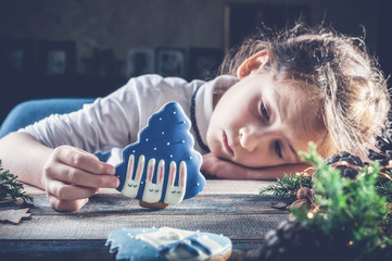 Caucasian girl with Christmas gingerbread did not wait for Santa Claus and sleeps. Child Psychology...