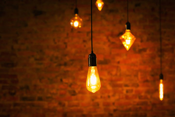  Beautiful yellow incandescent bulbs on a background of dark red red brick wall