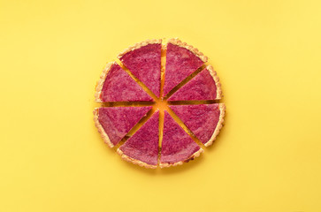 Sliced cranberry pie on yellow background. Homemade sweet pastry