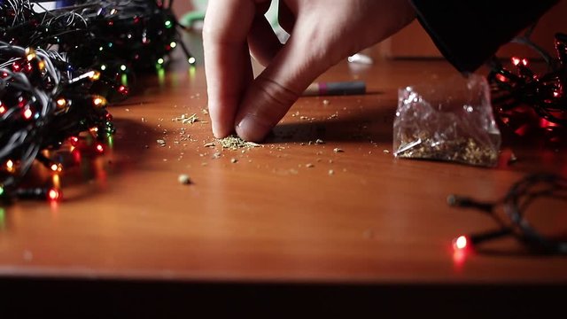 marijuana on the table, preparing to twist the jamb