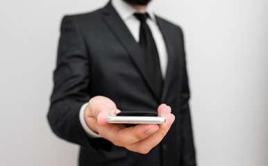 Male human wear formal work suit hold smart hi tech smartphone use one hand