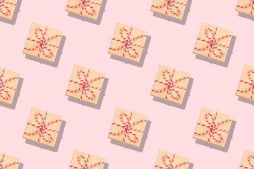 Pattern of Christmas gifts on pink background.