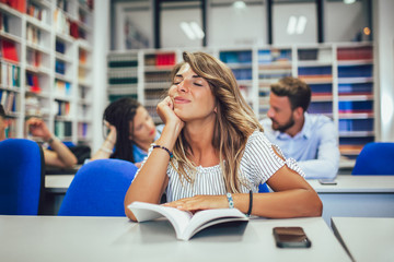 Students are studying in library. Young people are spending time together.