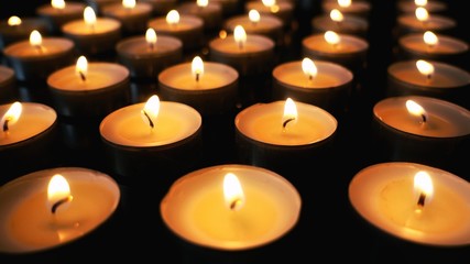 Lit tea candles on black background