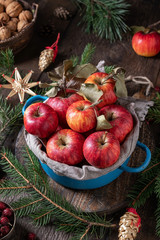 Fresh apples with Christmas straw ornaments and spruce branches