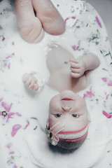 Obraz na płótnie Canvas baby in milk with flowers