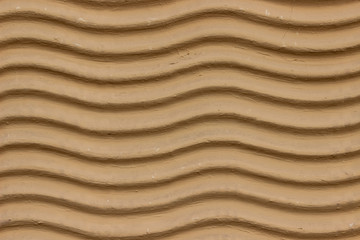 A decorative wall with a wavy structure painted in beige