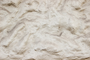 A decorative wall with a wavy structure painted in beige