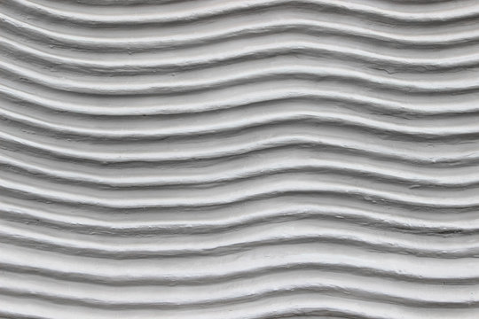 A decorative wall with a wavy structure painted in gray