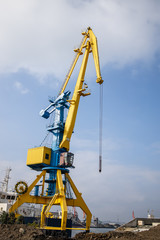 Working cranes in Bourgas - Bulgaria port in sunny weather. Industrial crane for unloading and loading in sea. Vertical image.
