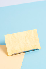 Paper placed tilted above buffer wire on soft pastel multi colours backdrop