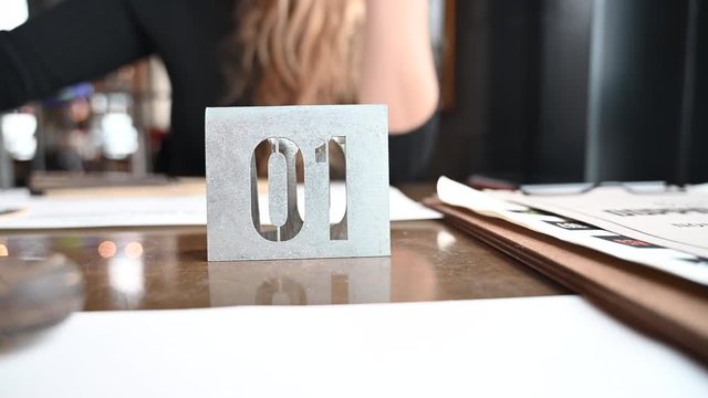 hungry couple at restaurant waiting to take order at the table, man playing with fork, place card number 01