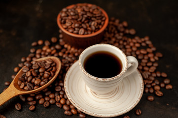 Cup of coffee and different beans on a stone background.