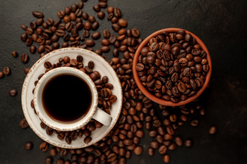 Cup of coffee and different beans on a stone background.