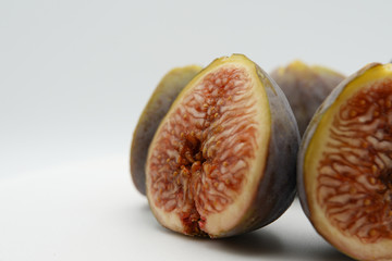 Cut ripe fig fruit cut in pieces, macrophotography. Close-up of fresh fig full of seeds inside. Vitamins and nutrition concept