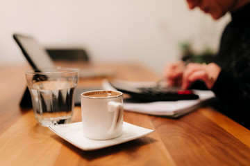 middle aged business woman is working at home. Late at night she is doing overtime with her tablet computer and writing 'to do' notes 