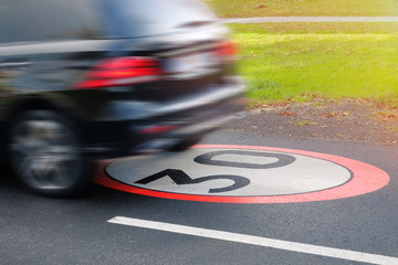 A moving car in violation of traffic rules, limiting the maximum speed to 30.