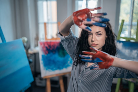 young beautiful female drawing abstract picture by fingers