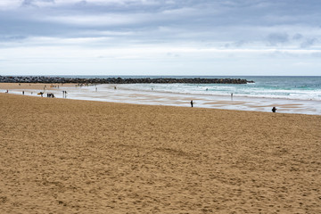 Embankment and city sand beach. San Sebastian, Spain. 26 nov 2019 Rest of people and water sports on the beach in autumn period.