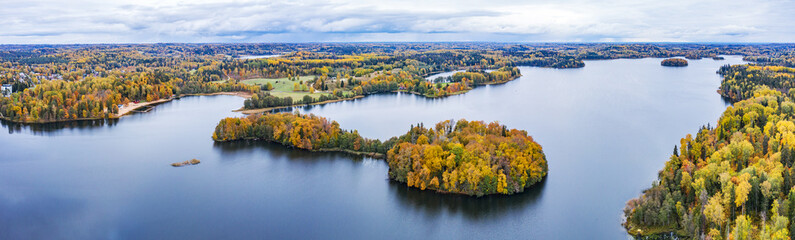 Island in the lake and forest in autumn colors. Golden trees and a blue water, nature environment....