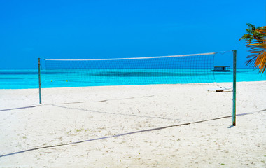 Volleyball net on a deserted sandy beach on the tropical sea.