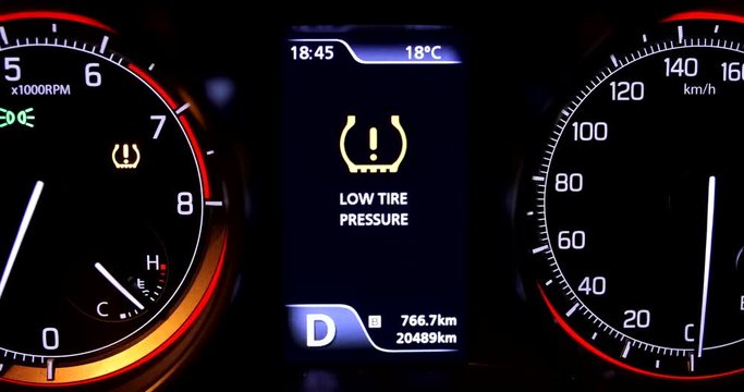 Warning lights flash on car dashboard. Low tire pressure error sign.