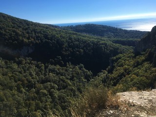 Obraz premium The green mountains against the blue sea and sky