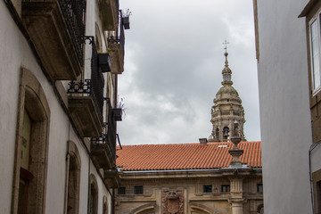 Santiago de Sompostela landmark. Tower of cathedral of Saint James. Pilgrimage centre. Buildings at old medieval street. Camino de Santiago concept. European architecture.
