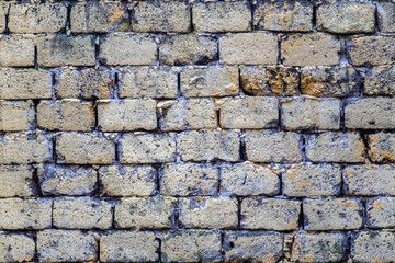 old shabby beige castle wall made of concrete gray bricks. rough surface texture