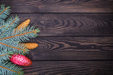 Beautiful Christmas border of spruce and toys on a black wooden vintage background