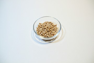 Glass bowl with pile of chickpeas isolated on white background