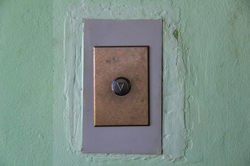 modern elevator arrow button on old shabby wall