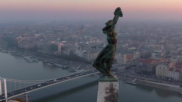 Budapest, Hungary, aerial view of historical landmark Liberty Statue and Budapest cityscape at sunrise.