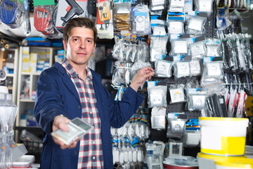 Smiling seller in hardware store is trading sockets