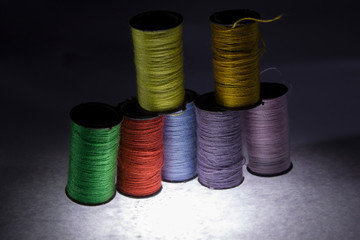 Colored threads for sewing. Skeins of colored threads on a black background