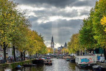 Nieuwmarkt and Zuiderkerk as seen from across the canal with a beautiful sunlight ray