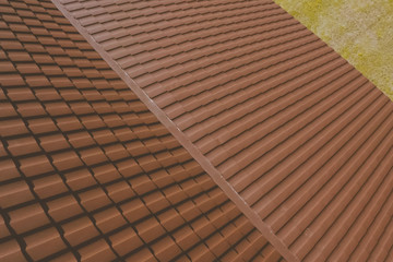 Brown metal tile on the roof of the house. Corrugated metal roof