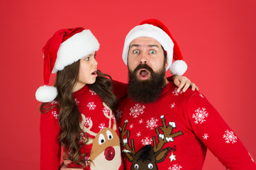 Weird things going on. Father and daughter winter sweaters celebrate new year. Happy family hug. Concentrated faces. Merry christmas. Bearded man and kid. Family celebrate holiday. Family tradition