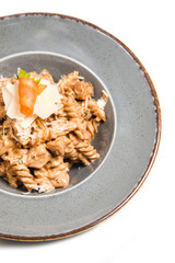 Homemade pasta with chicken, cheese and piece of carrot in a rustic plate