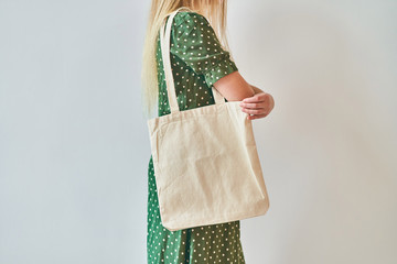 Fototapeta A Girl is holding blank cotton eco tote bag, design mockup. obraz
