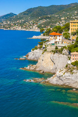 Camogli rocky coast aerial view. View from harbor with green water.