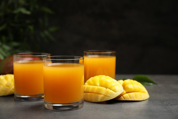 Fresh delicious mango drink on grey table