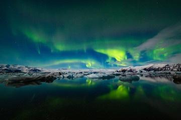 Naklejka na ściany i meble Aurora Borealis over a glacier lagoon in Iceland