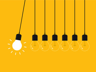 Newton's cradle with glowing light bulb. Pendulum. Leadership, power and uniqueness concept.