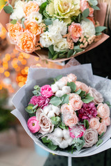 European floral shop. Two Beautiful bouquets of mixed flowers in womans hands. the work of the florist at a flower shop. Delivery fresh cut flower.