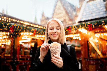 beautiful blonde with spit cake at the Christmas market in Wroclaw, Poland